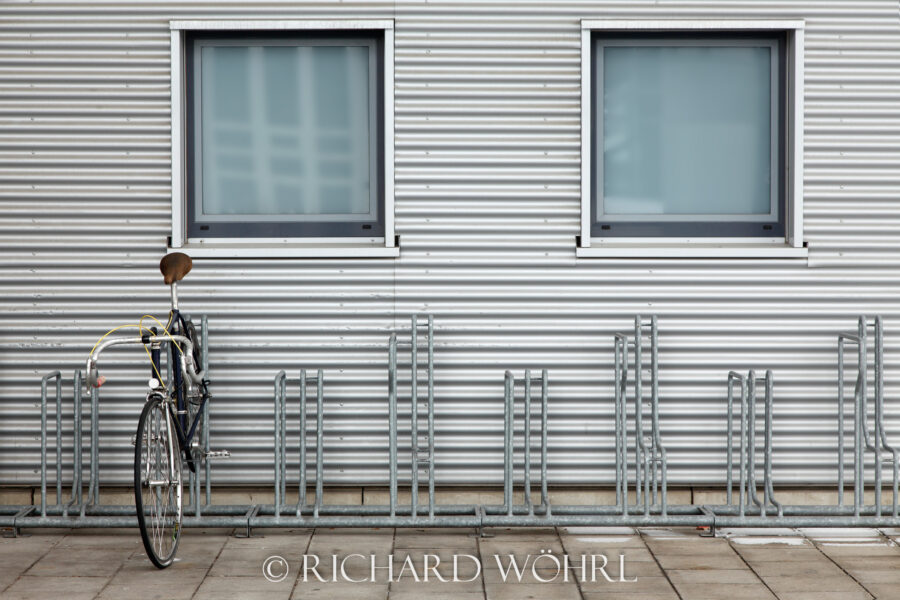 Abgestelltes Fahrrad vor einer Wand aus Wellblech